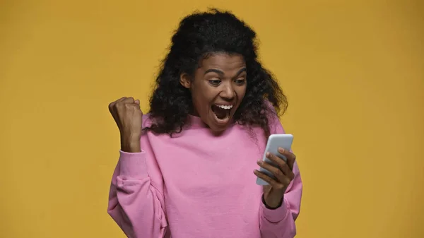 Amazed African American Woman Pink Sweatshirt Using Smartphone Isolated Yellow — Stockfoto
