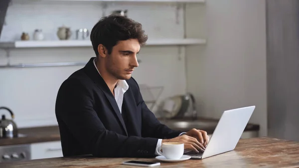 Freelancer Using Laptop Smartphone Cup Coffee Desk — стоковое фото