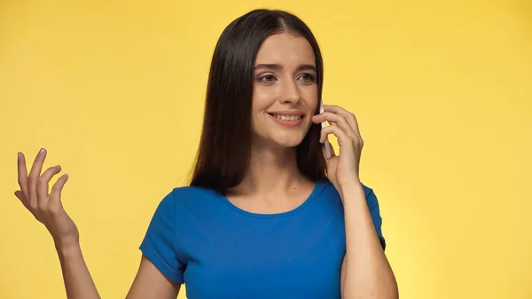 Молодая Счастливая Женщина Голубой Футболке Говорит Смартфоне Изолированы Желтый — стоковое фото