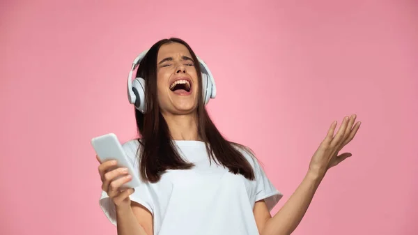 Brunette Jonge Vrouw Draadloze Hoofdtelefoon Zingen Houden Smartphone Geïsoleerd Roze — Stockfoto