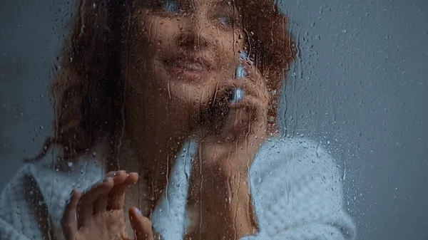 Cheerful Curly Woman Talking Smartphone Window Glass Raindrops — Stock Photo, Image