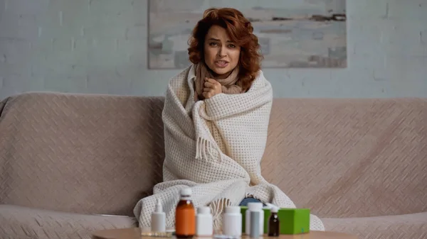Sick Redhead Woman Talking Camera While Sitting Medication Coffee Table — 스톡 사진