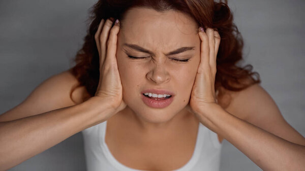 overhead view of woman with closed eyes suffering from headache