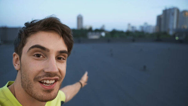Positive Sportsman Looking Camera Pointing Blurred Roof Evening — Photo
