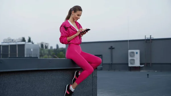 Smiling Sportswoman Using Smartphone Roof Building Evening — Fotografia de Stock