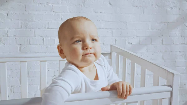Adorable Baby Blue Eyes Standing White Baby Crib Home — 스톡 사진