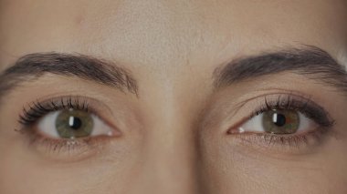 close up view of woman with hazel eyes and mascara on eyelashes looking at camera  clipart