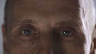 cropped view of middle aged man with wrinkles looking at camera isolated on grey 