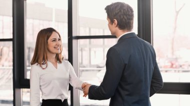 happy woman shaking hands with employer after job interview clipart