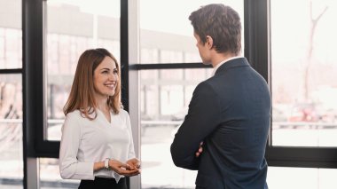businessman listening to smiling woman talking during job interview