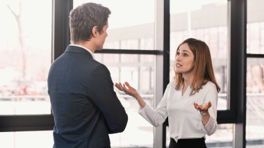 emotional woman gesturing during job interview with businessman in office