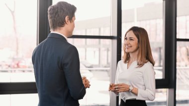 pretty woman smiling near businessman during job interview