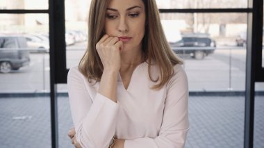 tense woman touching face while waiting for job interview
