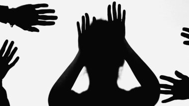 black shadow of bullied woman gesturing near hands of people isolated on white