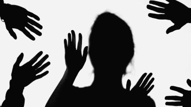 shadows of hands of people near bullied woman gesturing isolated on white