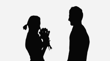 black shadows of woman with flowers near man isolated on white
