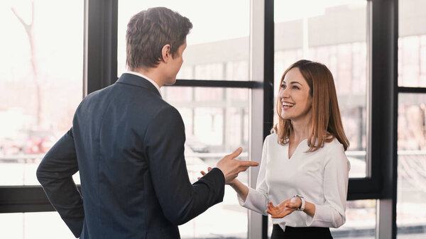 smiling woman and businessman gesturing during job interview