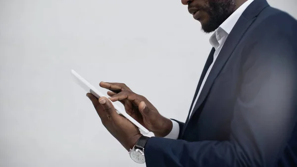 Vue recadrée d'un homme d'affaires afro-américain utilisant une tablette numérique isolée sur gris — Photo de stock