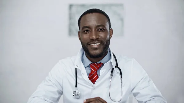 Heureux médecin afro-américain avec stéthoscope regardant la caméra — Photo de stock