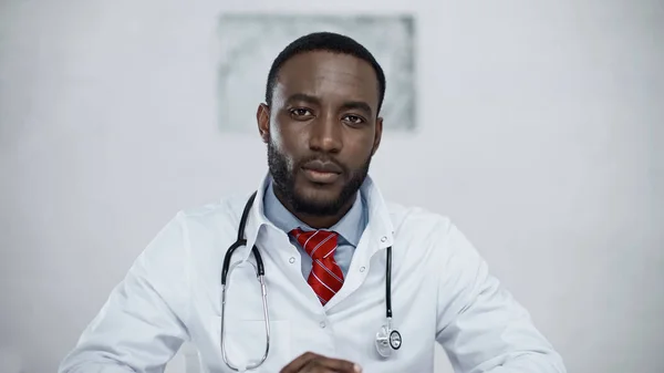 Серйозний афроамериканський лікар зі стетоскопом, дивлячись на камеру — стокове фото