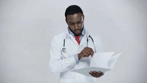 Afrikanisch-amerikanischer Arzt hält Mappe mit Papieren isoliert auf grau — Stockfoto
