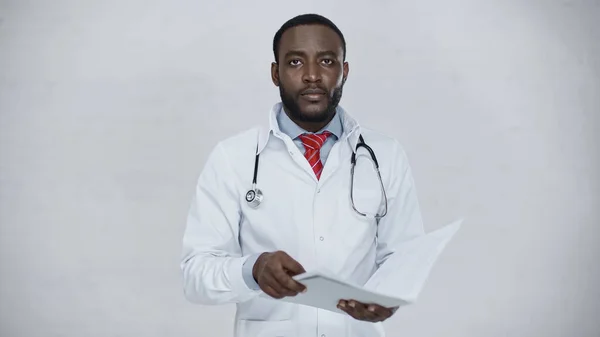 Afrikanisch-amerikanischer Arzt hält Mappe mit Dokument isoliert auf grau — Stockfoto