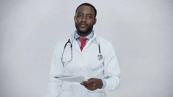 Bearded african american doctor holding folder isolated on grey — Stock Photo