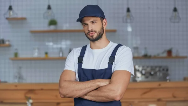 Delivery man in overalls looking at camera at home — Stock Photo