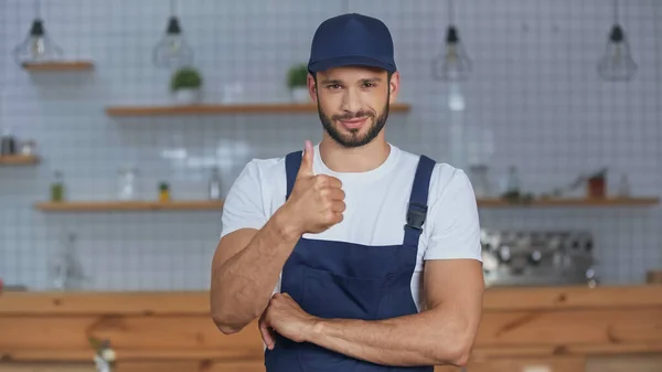 Zusteller in Overalls zeigt wie Geste zu Hause — Stockfoto