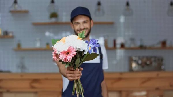 Flores na mão de homem de entrega desfocado em casa — Fotografia de Stock