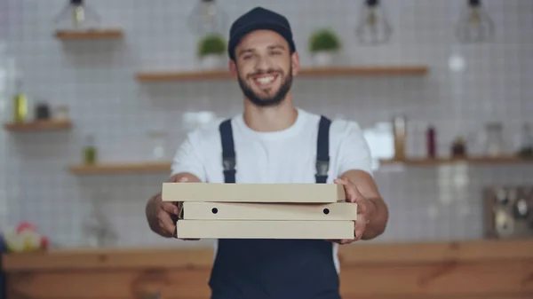 Caixas de pizza em mãos de homem de entrega desfocado em casa — Fotografia de Stock