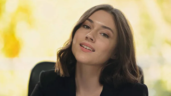 Молодая и красивая деловая женщина, улыбающаяся в офисе перед камерой — стоковое фото
