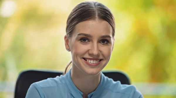 Cheerful young manager smiling while looking at camera in office — Stock Photo