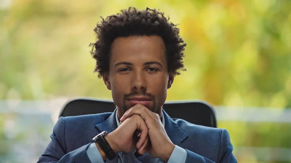 Young and confident african american businessman in formal wear looking at camera in office — Stock Photo