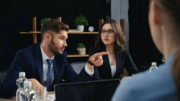 Uomo d'affari che punta il dito durante l'incontro con i colleghi in carica — Foto stock