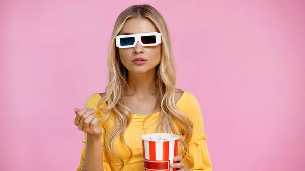 Blonde Frau in 3D-Brille hält Popcorn isoliert auf rosa — Stockfoto