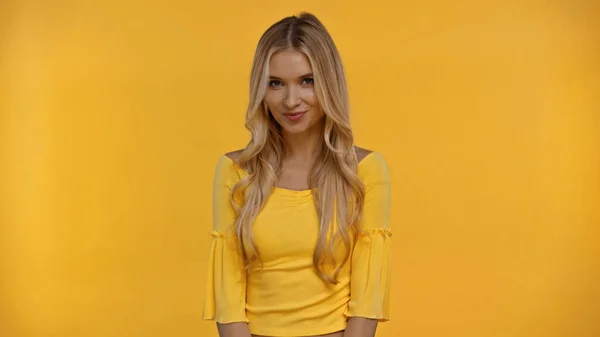 Усміхнена блондинка дивиться на камеру ізольовано на жовтому — стокове фото