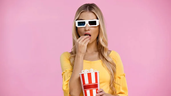 Donna bionda in occhiali 3d mangiare popcorn isolato su rosa — Foto stock