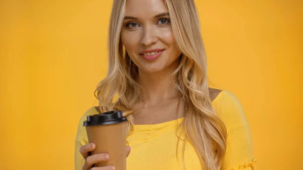 Lächelnde blonde Frau mit Kaffee zum Isolieren auf gelb — Stockfoto