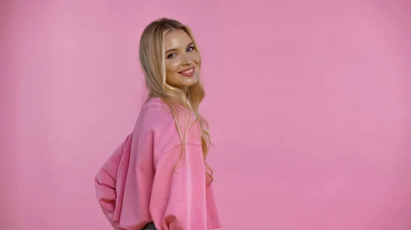 Mujer rubia bonita sonriendo a la cámara aislada en rosa - foto de stock