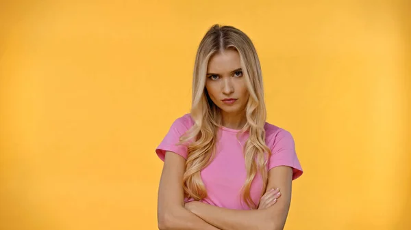 Mulher loira perturbada em camiseta rosa olhando para a câmera isolada no amarelo — Fotografia de Stock