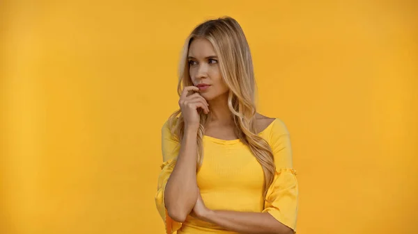Mujer pensativa mirando hacia otro lado aislado en amarillo - foto de stock