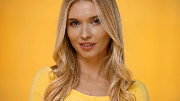 Mulher loira bonita em blusa olhando para a câmera isolada no amarelo — Fotografia de Stock
