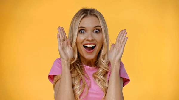 Excited blonde woman looking at camera isolated on yellow — Stock Photo