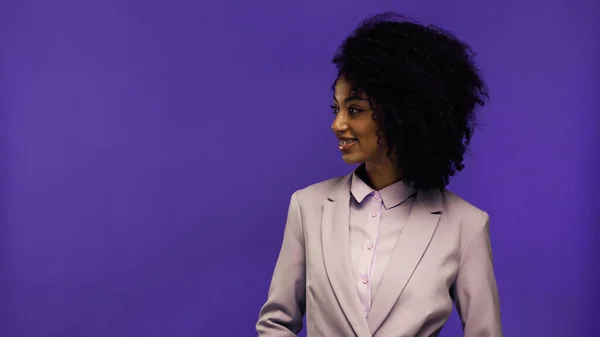 Cheerful african american businesswoman with braces looking away isolated on purple — Stock Photo