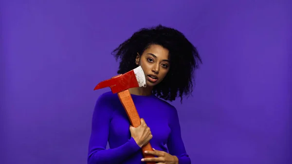 Cheerful african american woman with braces holding hammer isolated on purple — Stock Photo