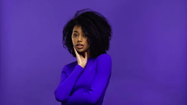 Afro-americana jovem mulher com aparelho olhando para câmera isolada em roxo — Fotografia de Stock