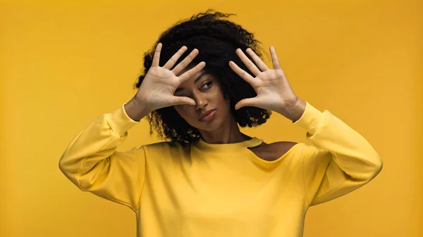 Bonita jovem afro-americana realizando mímica atuando isolado no amarelo — Fotografia de Stock