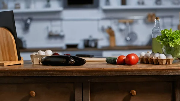 Fresh ingredients and bottle with oil in modern kitchen — Stock Photo