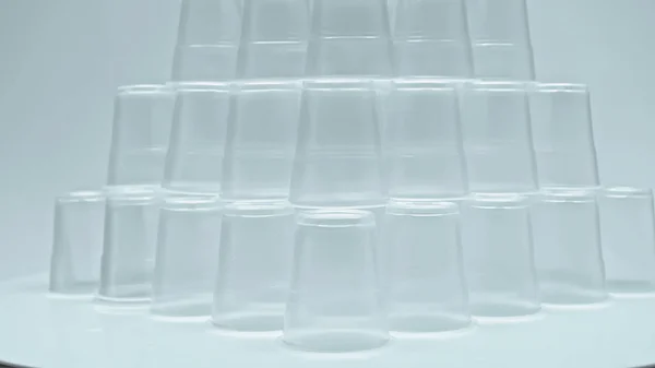 Piramide di bicchieri di plastica su grigio — Foto stock